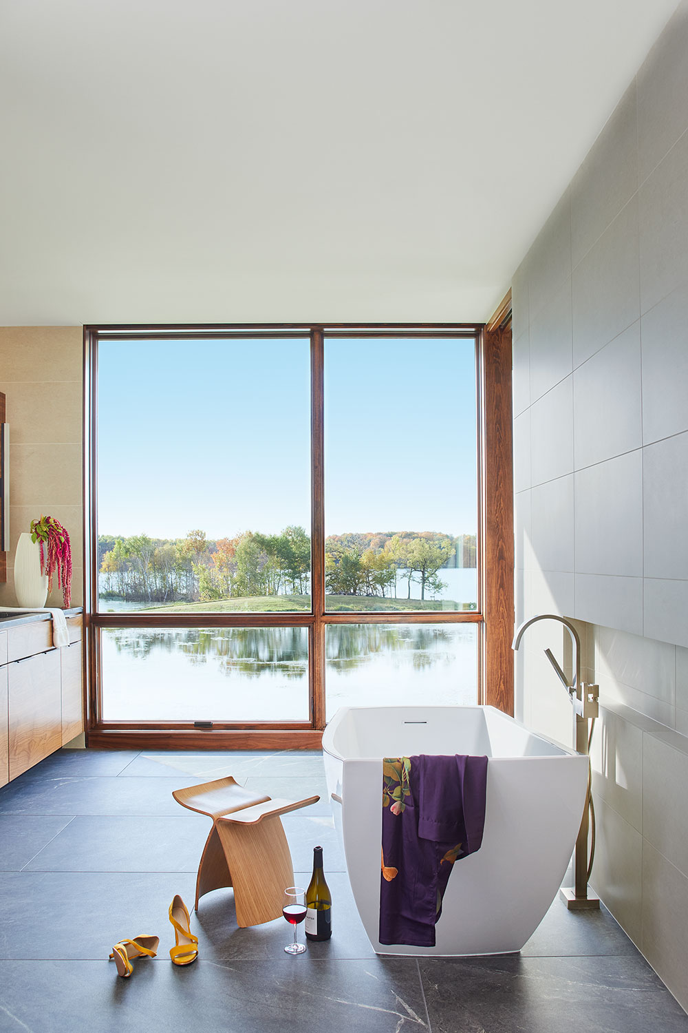 Wood-framed window with lakefront view in bathroom