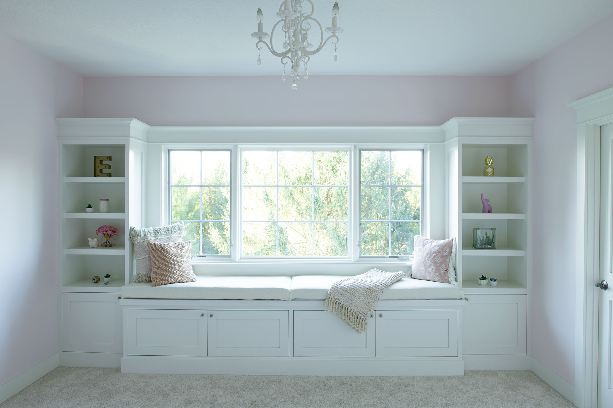 Bay window seat with built-in shelving in bedroom