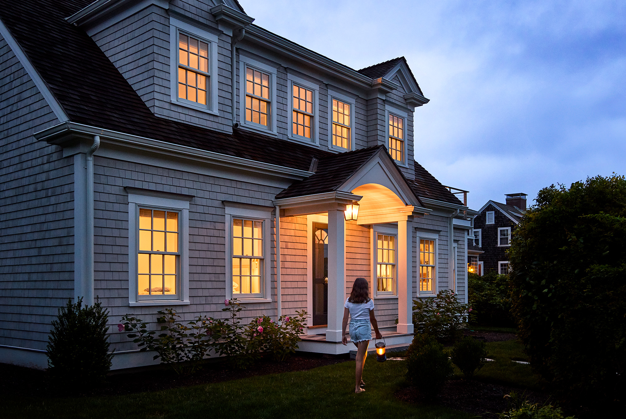 Cape Cod home with double-hung windows at dusk