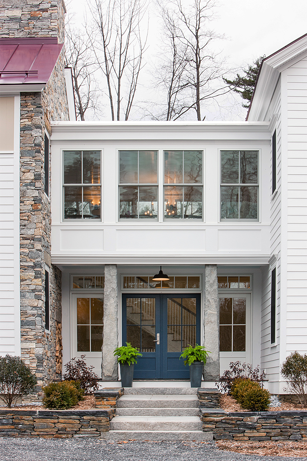 Double-hung windows on stone and clapboard residence