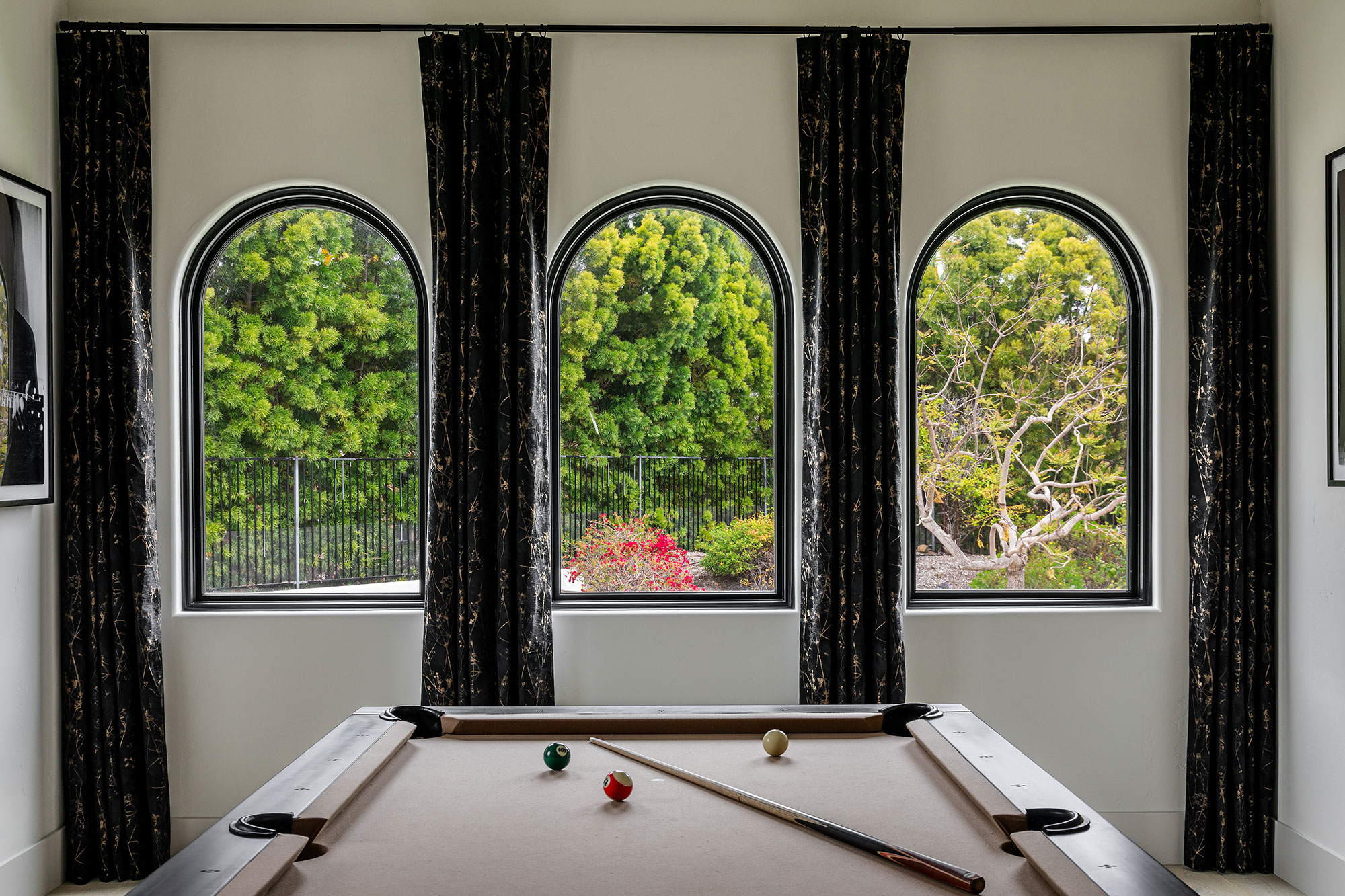 Three arched windows with garden view in game room